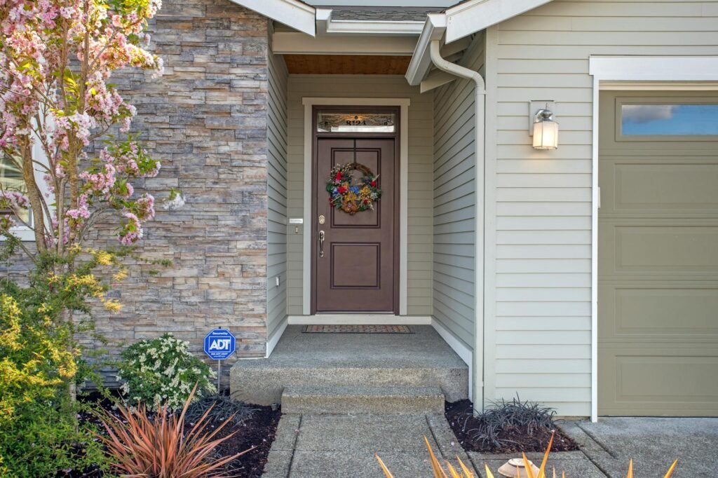 A well-kept front door with planters and a fresh welcome mat.