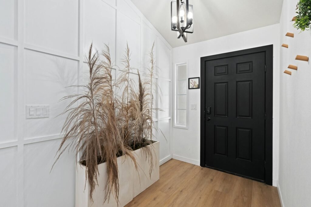 A tidy front entry with a neutral doormat, simple planter, and uncluttered walkway.
