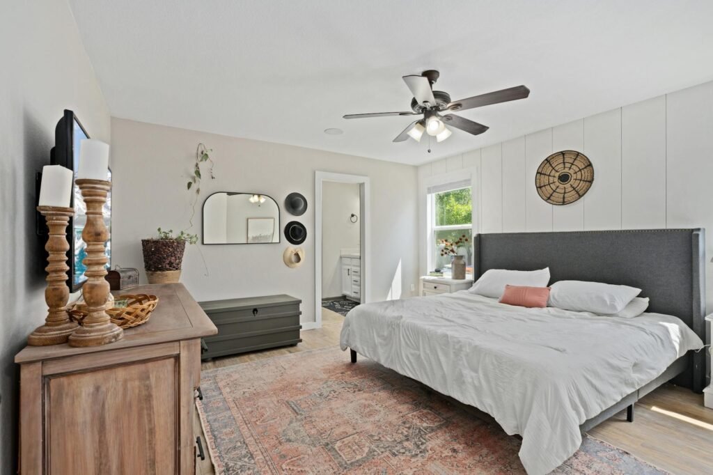 An edited flex room with one anchor piece, a mirror, and open floor space