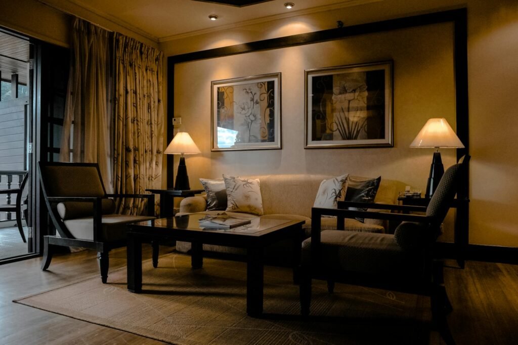 Warm layered lighting beside neutral curtains in a polished room