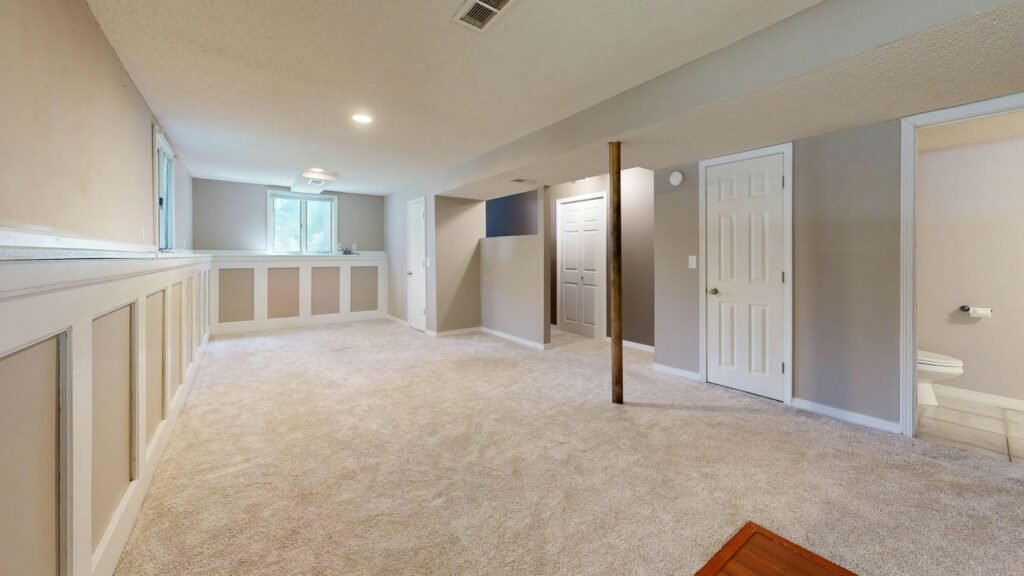 A bright living room with neutral furniture, open floor space, and simple decor