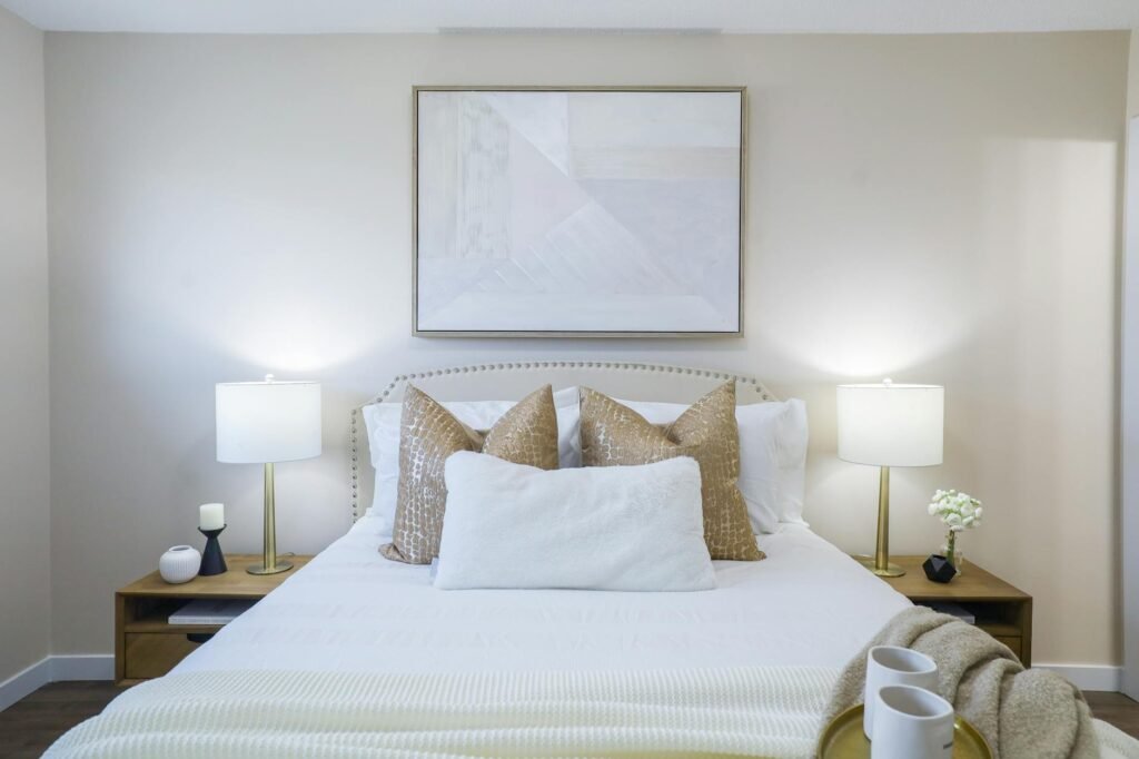 A calm primary bedroom with simple bedding, clear nightstands, and soft natural light.