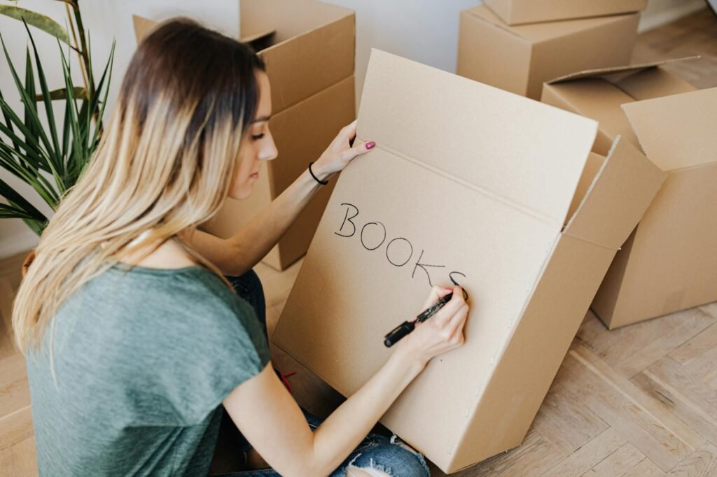 Boxes on the floor as a homeowner sorts decorative items to declutter before listing