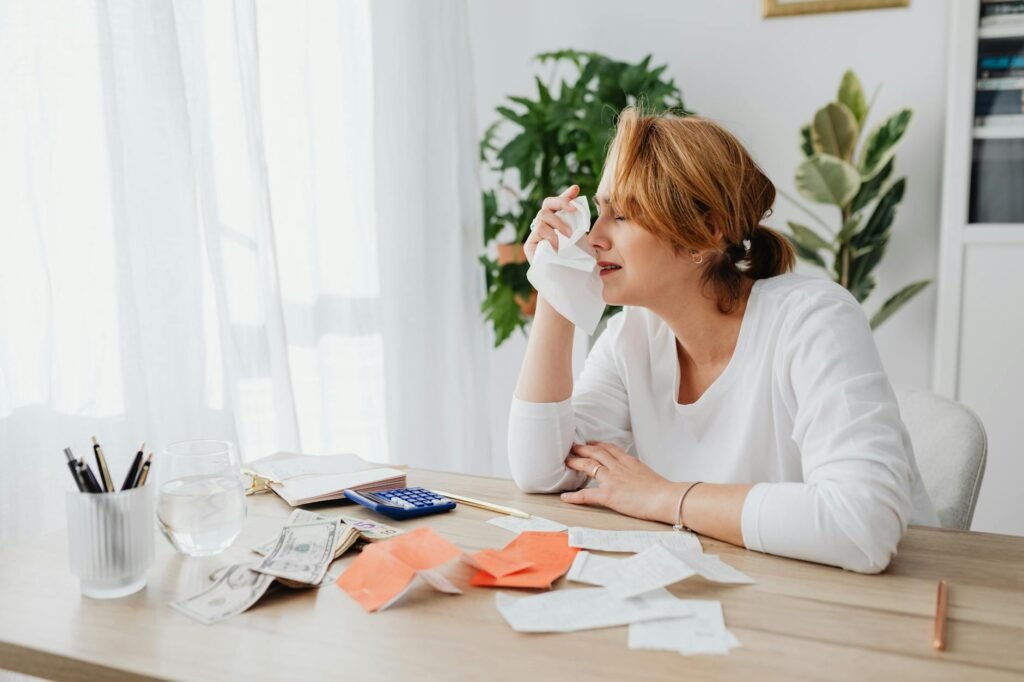 A homeowner reviewing staging expenses with a calculator, receipts, and paint samples.