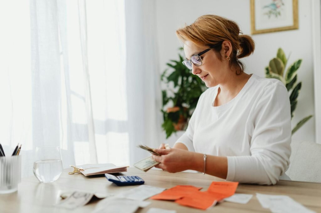 A desk with a calculator, receipts, a notepad, and LED bulb boxes for a pre-listing budget review.