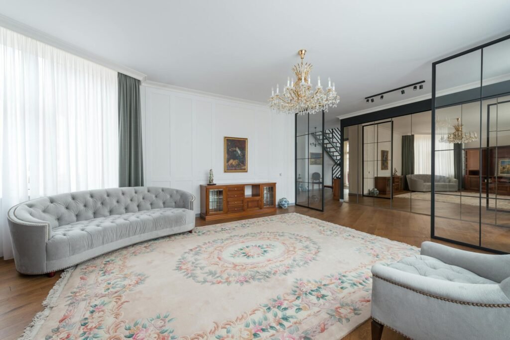 A staged living room with a large rug, warm layered lighting, and minimal clutter.