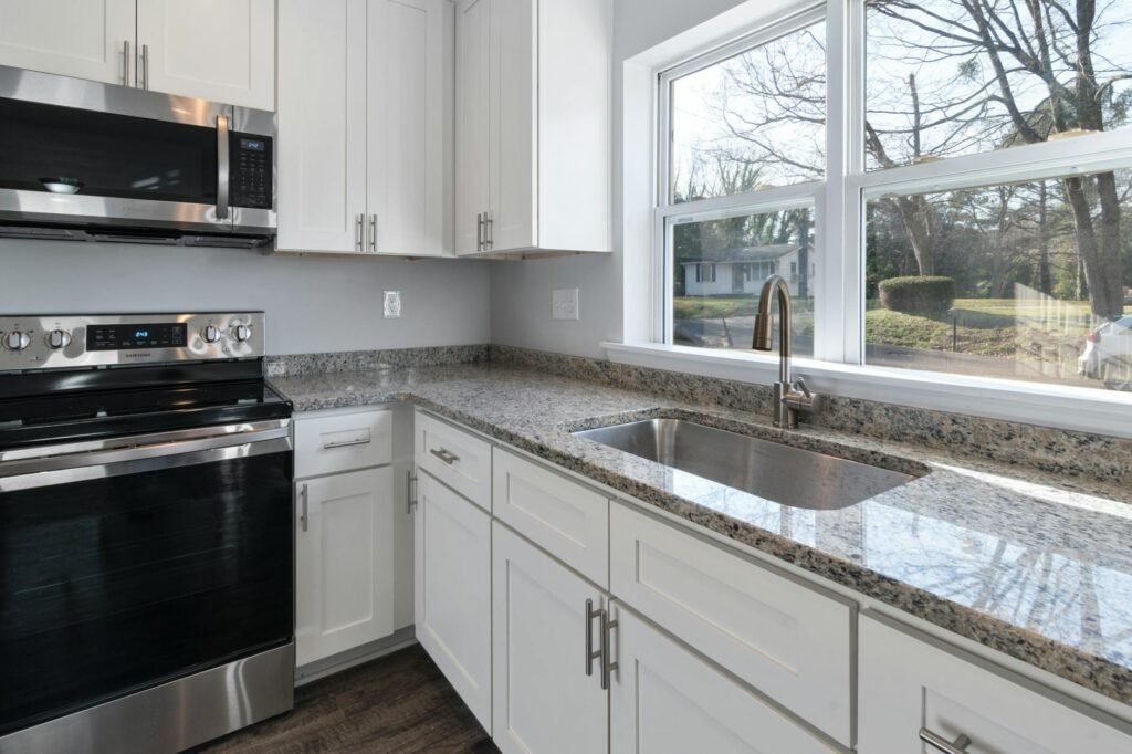 A staged kitchen with mostly clear counters and repeated metal finishes.