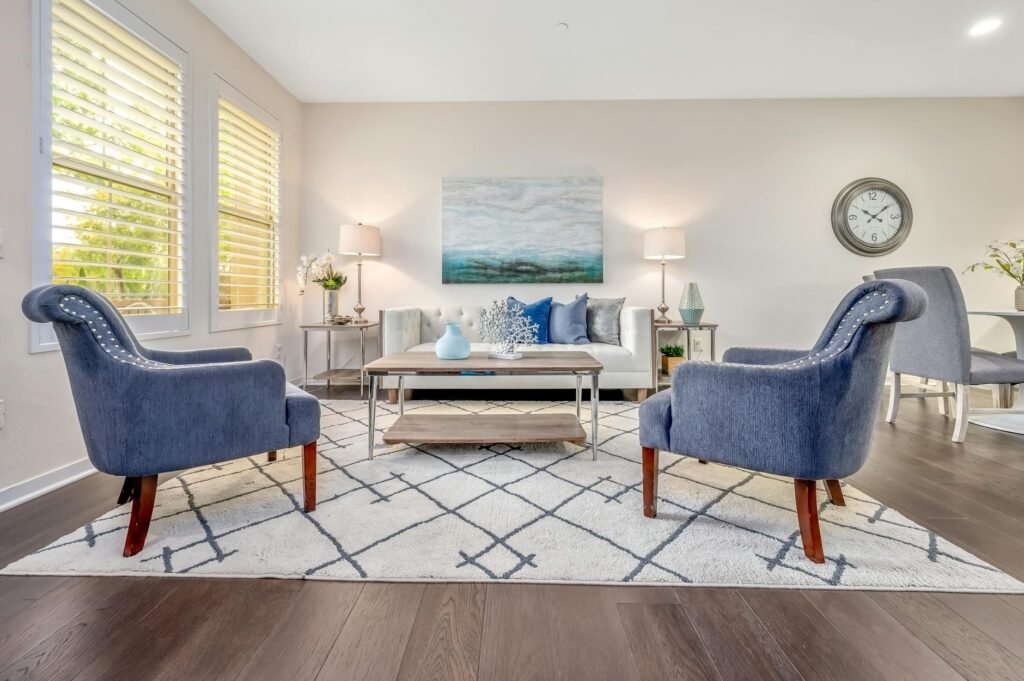 A bright staged living room with limited decor, open walking space, and natural light.