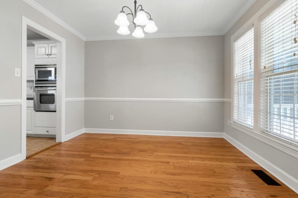 Paint sample boards compared against flooring and trim near a window