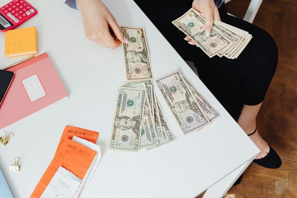 A home seller's staging budget worksheet with a calculator, receipts, and paint samples.