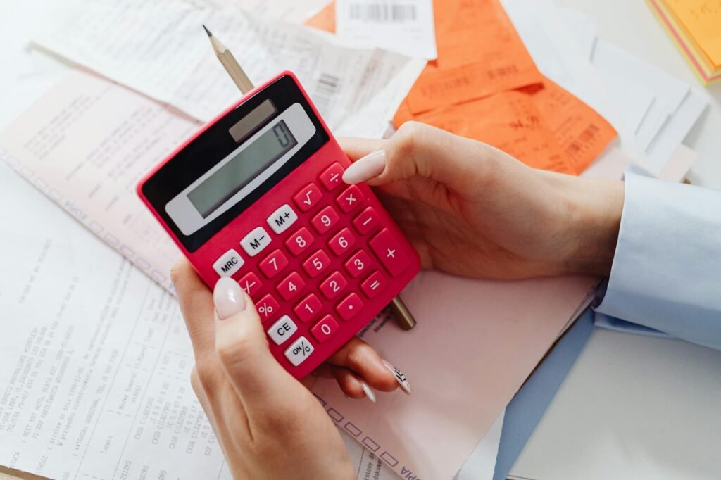 A homeowner reviewing a room update budget with paint samples, a calculator, and handwritten notes.