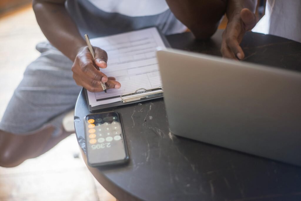 A notebook with a room checklist beside paint swatches, receipts, and a calculator.
